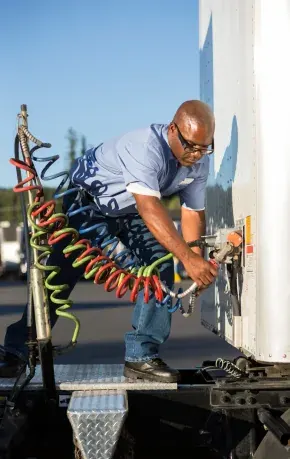 Driver connecting hoses before a road delivery
