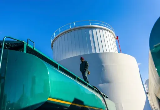 Operator on the gantry above storage tanks
